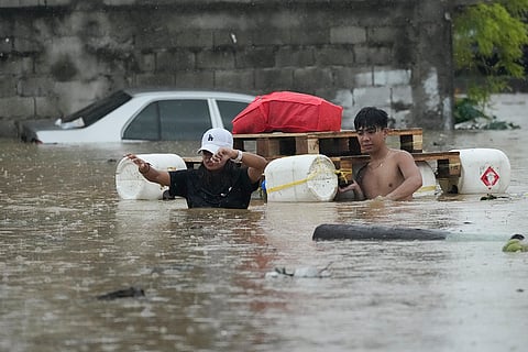 Philippines Tropical Storm Yagi: Residents wade with an improvised float